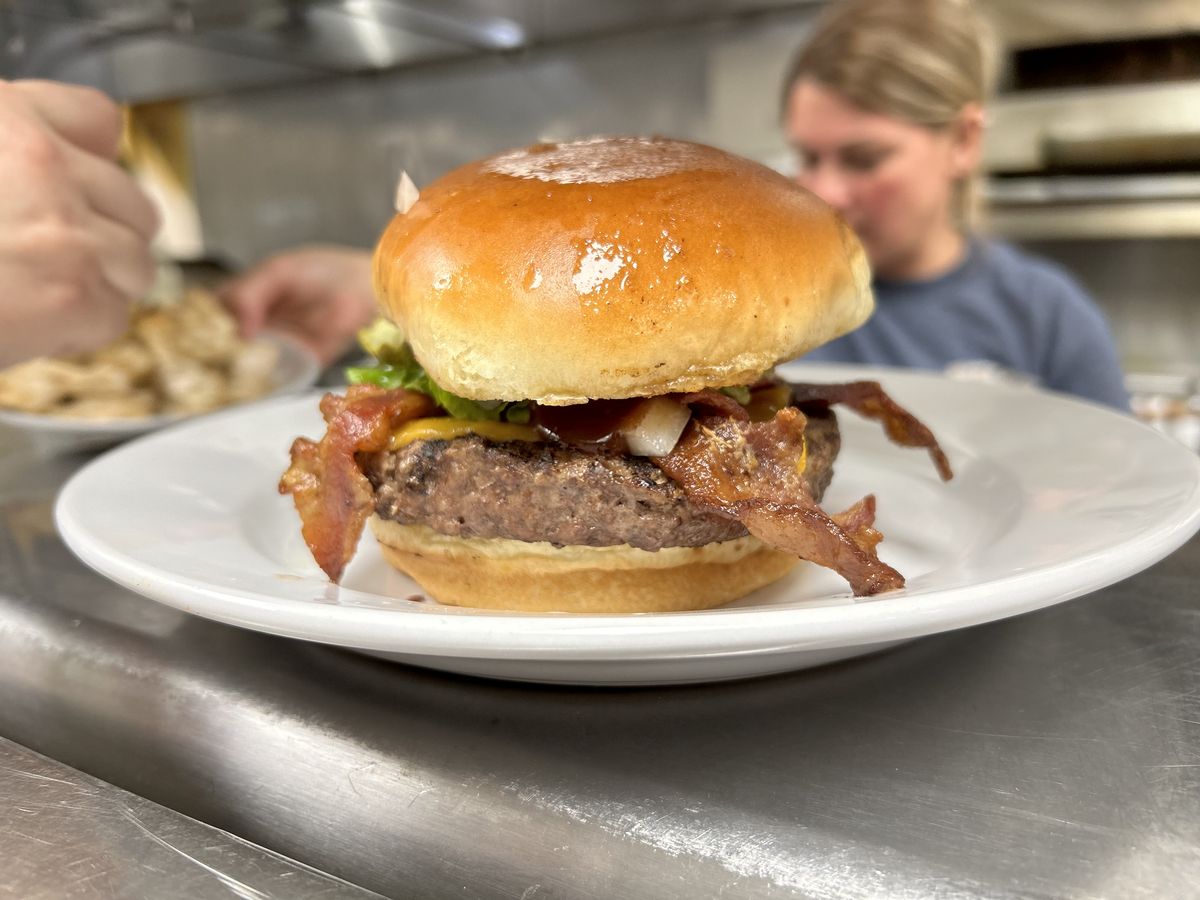 A bacon cheeseburger finished with BBQ sauce on a toasted bun