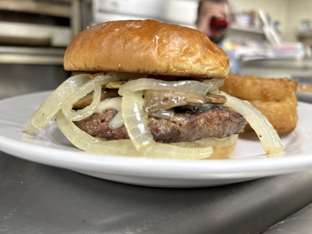A char-grilled burger piled with sweet grilled onions and onion rings