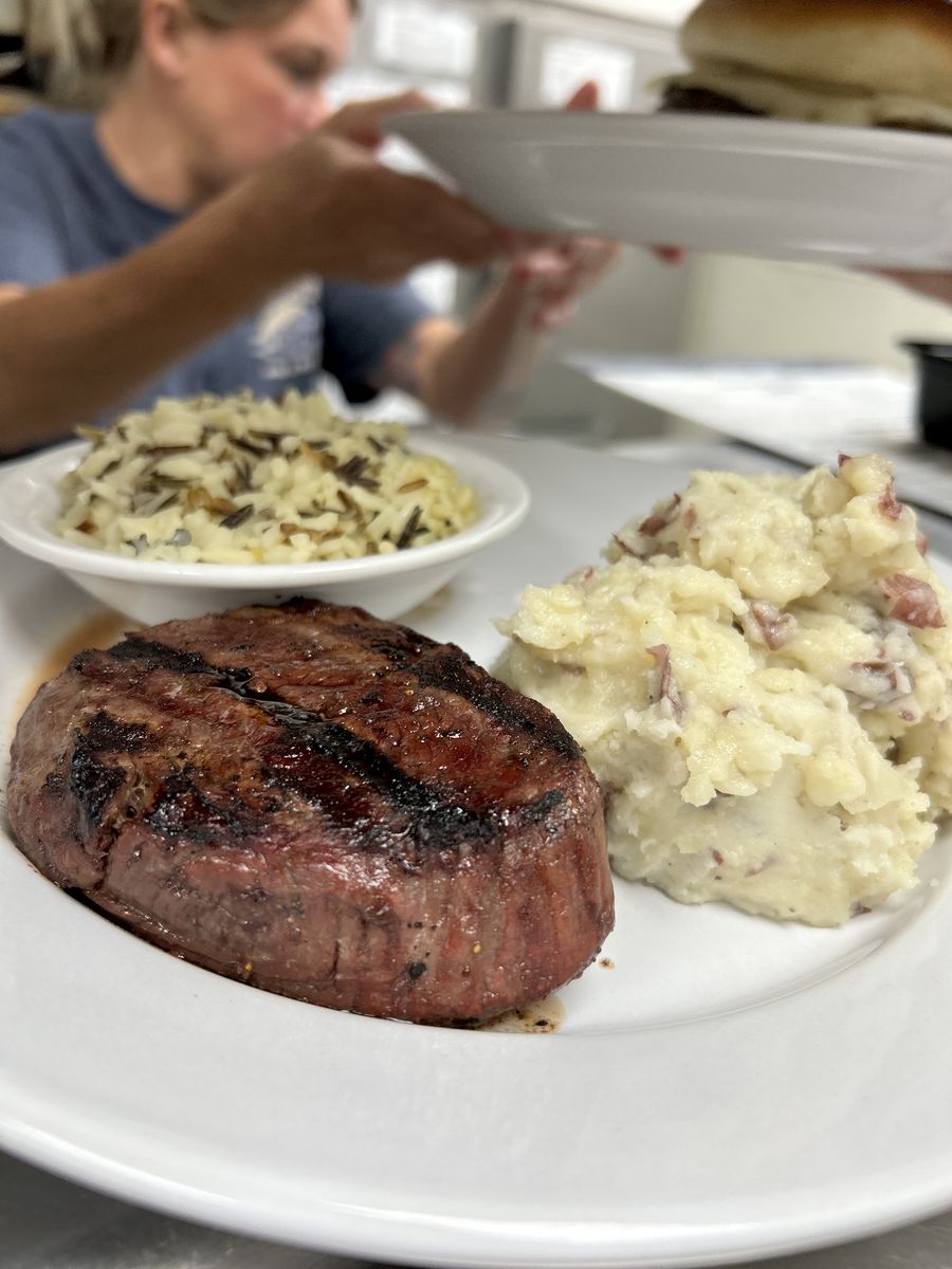 A char-grilled sirloin with mashed potatoes and wild rice